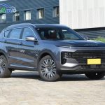 A grey Jetour X70 Plus SUV parked outside a factory building